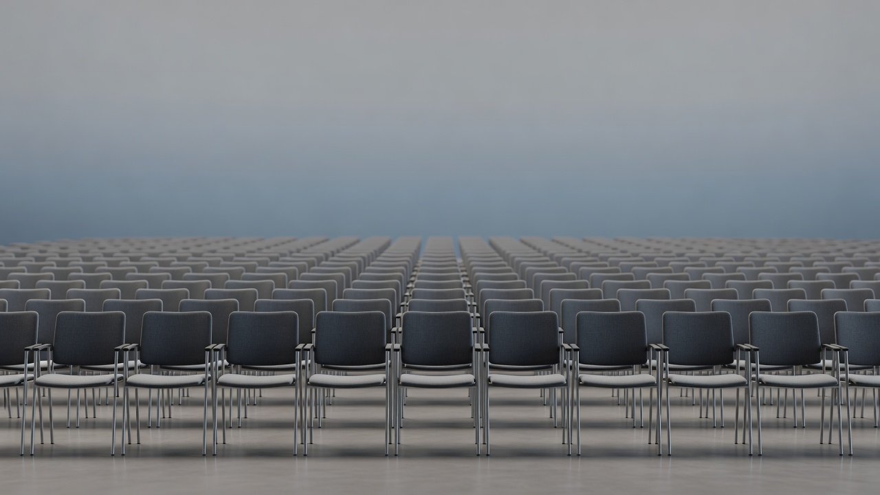 Rows of empty conference session chairs in a large hall, muted gradient background, shallow depth of field